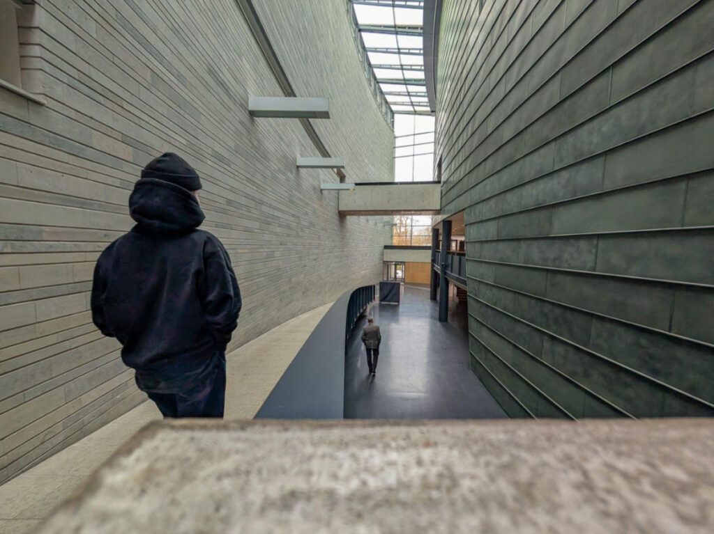 A man walking through the sleek, modern architecture of the KUMU art gallery
