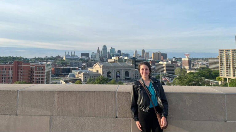 The author Kara Walters posing for a photo with an overlooking view of Kansas City skyline