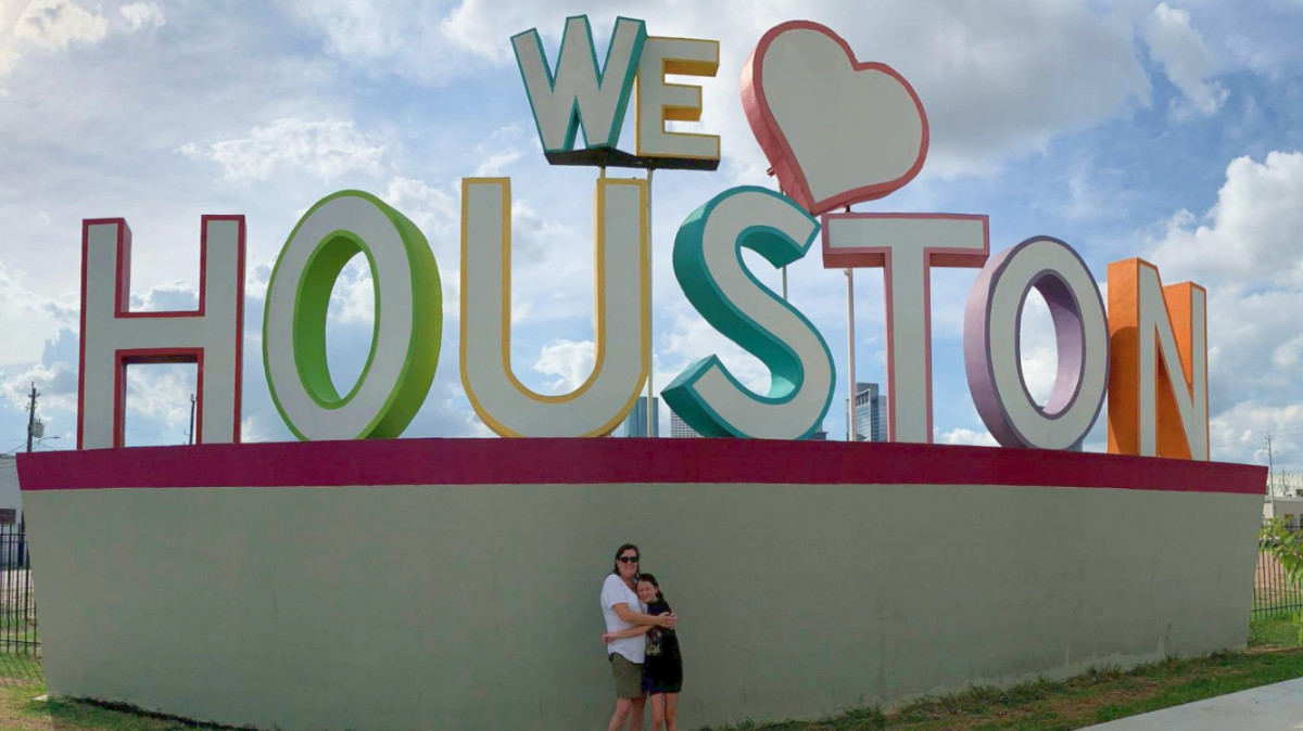 The author Karen Smith and her daughter posing in front of the "We love Houston" signage