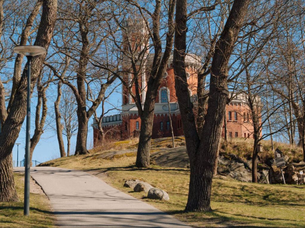 A pathway leading to the Kastellet Stockholm peeking through the trees