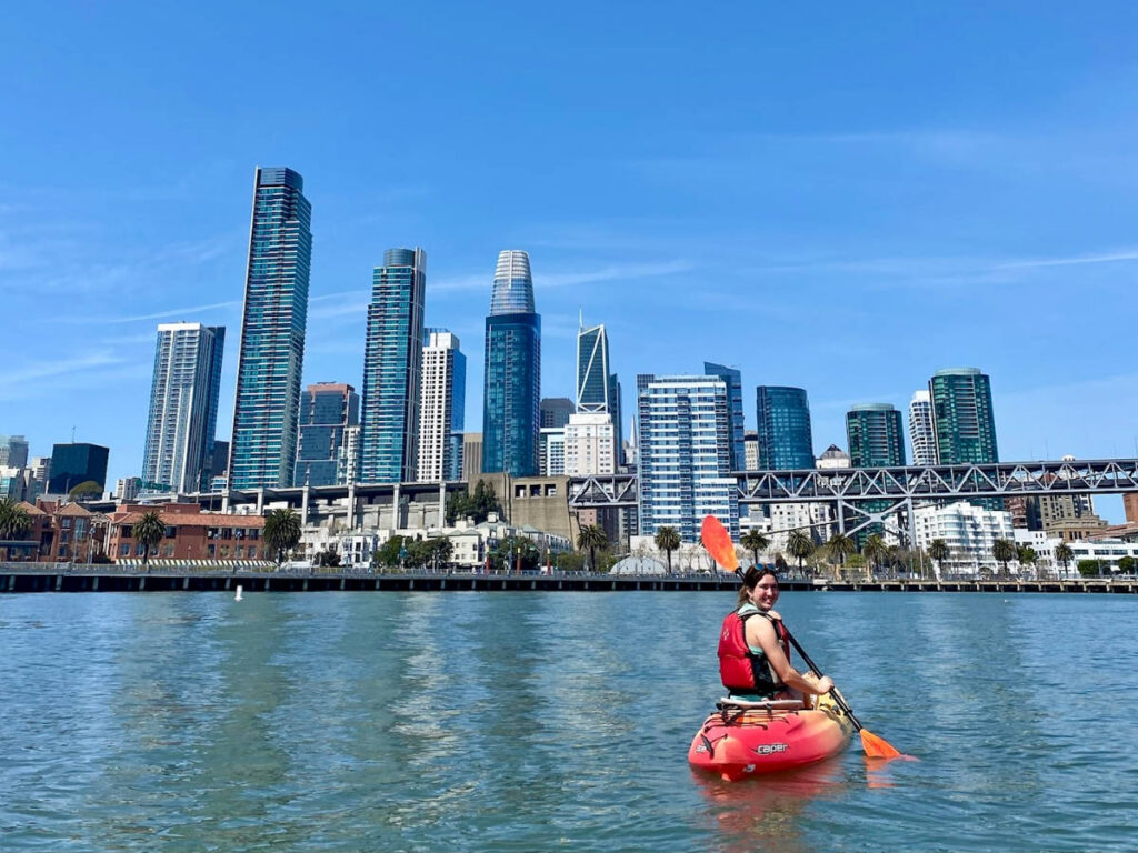 The author, Laura McFarland smiling for a photo while on her kayak in San Francisco