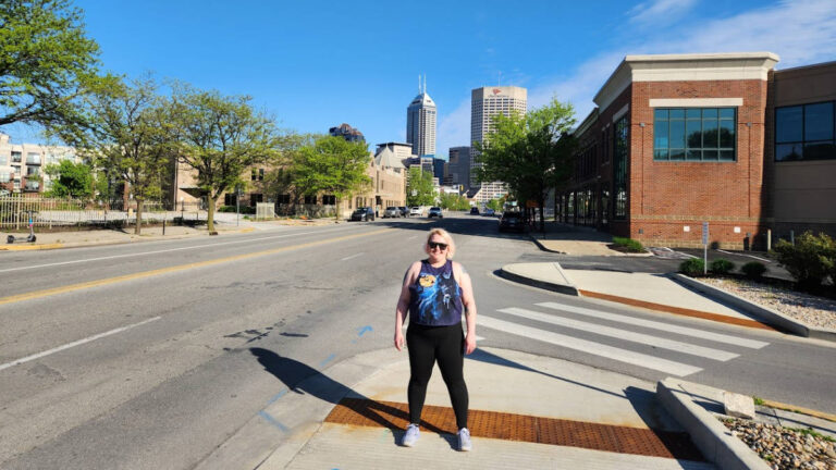 The author Kelsey Nighthawk posing for a photo at the downtown Indianapolis on a sunny day