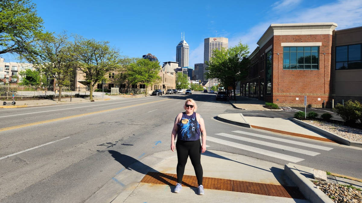 The author Kelsey Nighthawk posing for a photo at the downtown Indianapolis on a sunny day