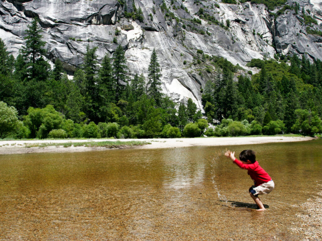 A kid playing on the Merced River in Yosemite National Park