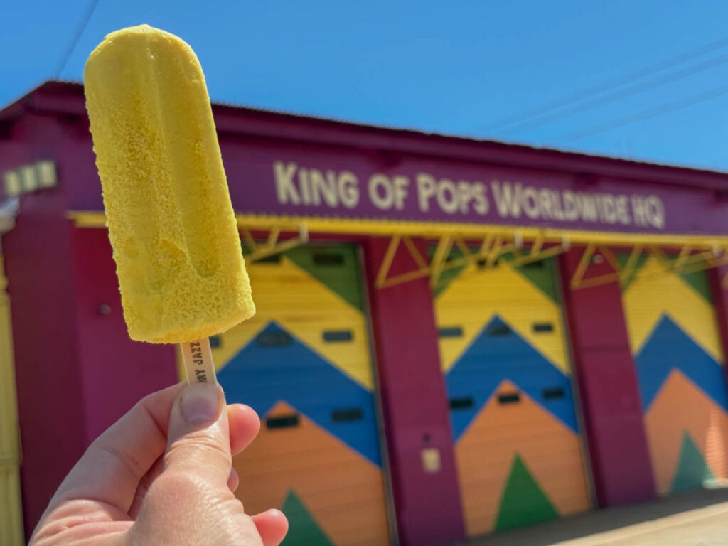 The author holding a King of Pops popsicle outside of their headquarters