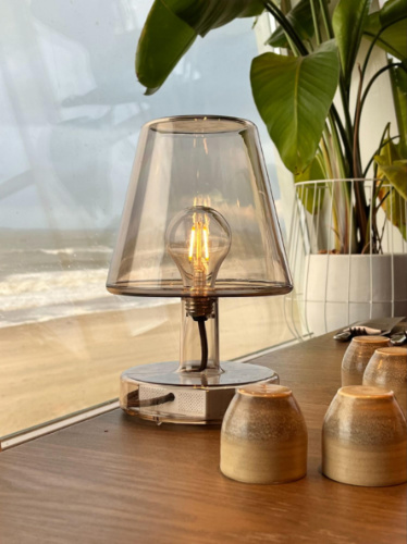Closeup look of the lamp and the cups on the wooden table