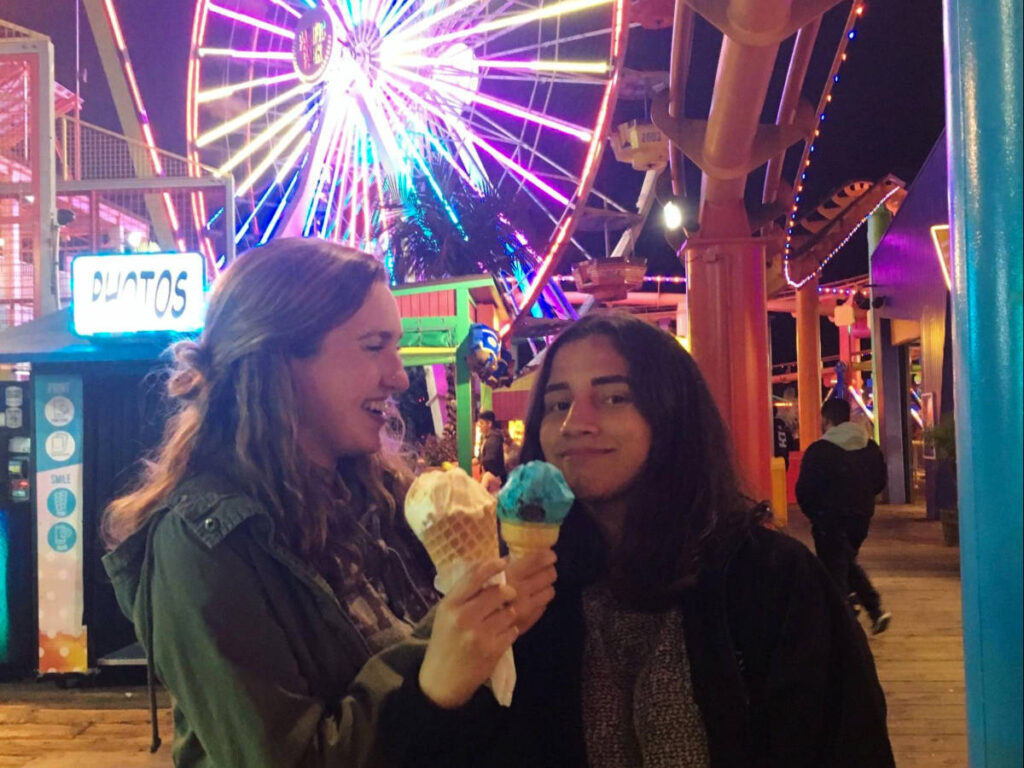 The author Laura McFarland and her friend eating ice cream in front of the ferris wheel in the Santa Monica Pier