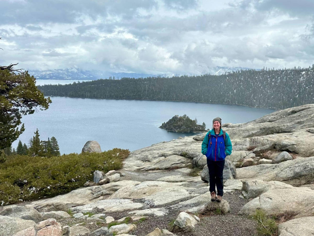 The author Laura McFarland posing for a photo with the Emerald Bay in the background