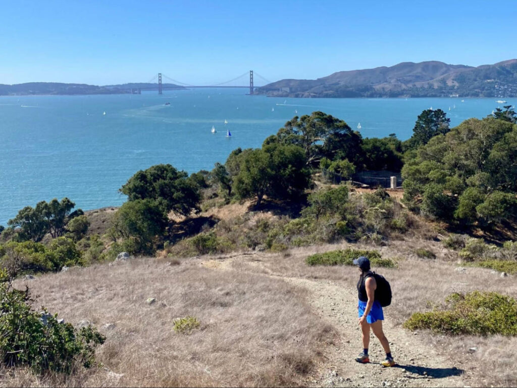 The author Laura McFarland, hiking on Angel Island with the view of the Golden Gate Bridge