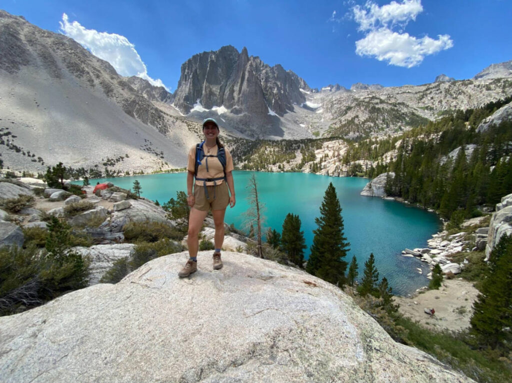 The author Laura McFarland, standing with an overlooking view of the lake at the Hiking to Big Pine Lakes