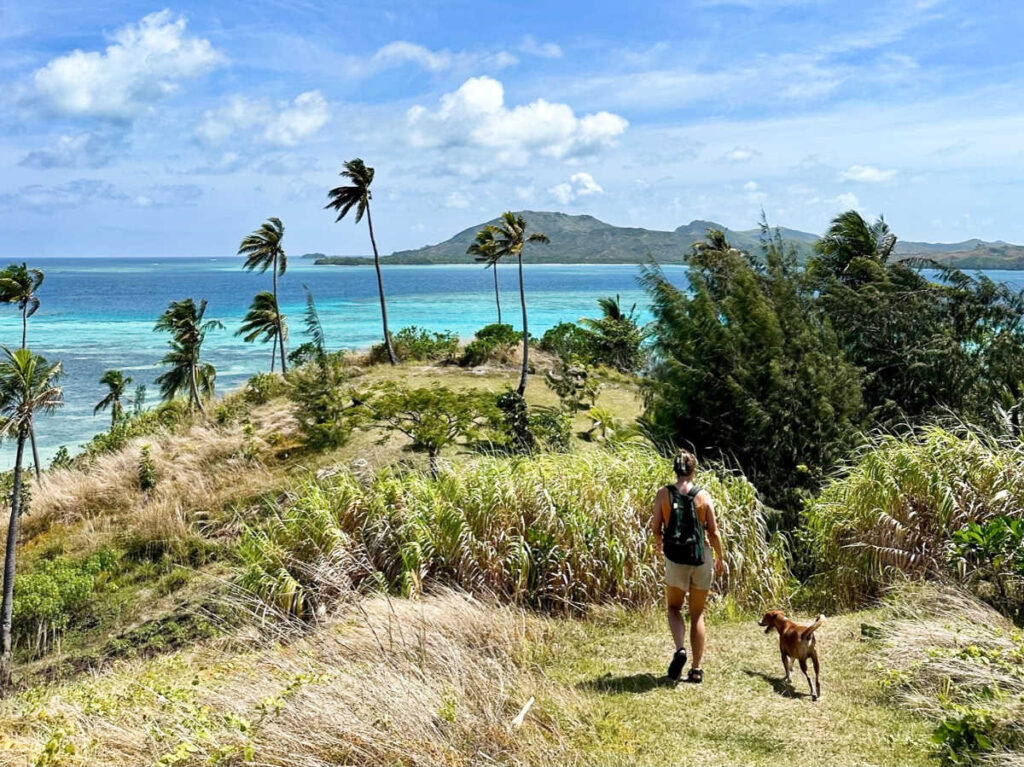 The author Laura McFarland hiking with a dog across Nanuya Lailai island