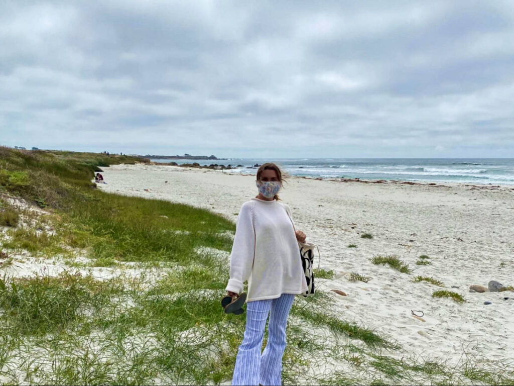 Thea author Laura McFarland, posing for a photo at the white sand beach in Monterey