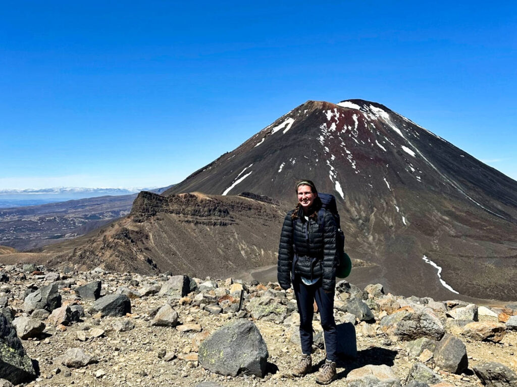 The author Laura McFarland smiling for a photo with the Mt. Ngauruhoe in the background