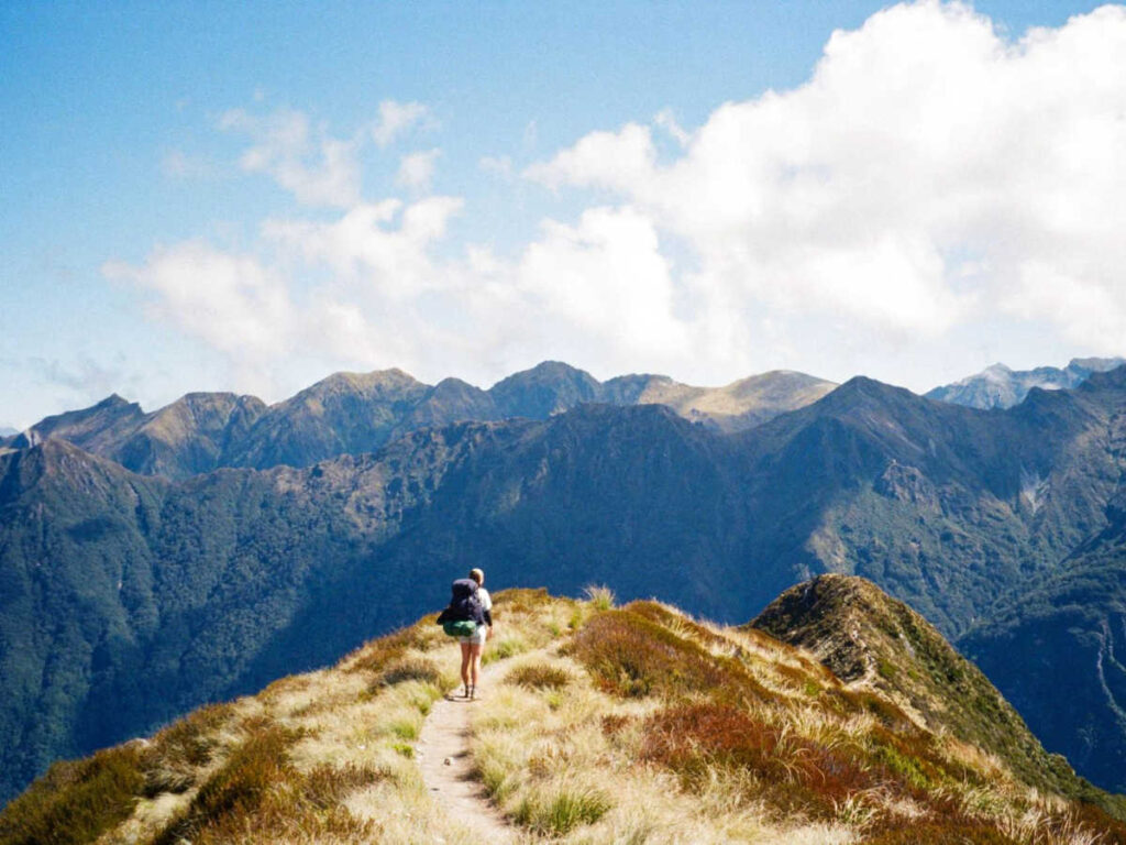 The author Laura McFarland standing on the hill overlooking the mountains of Fjordland National Park