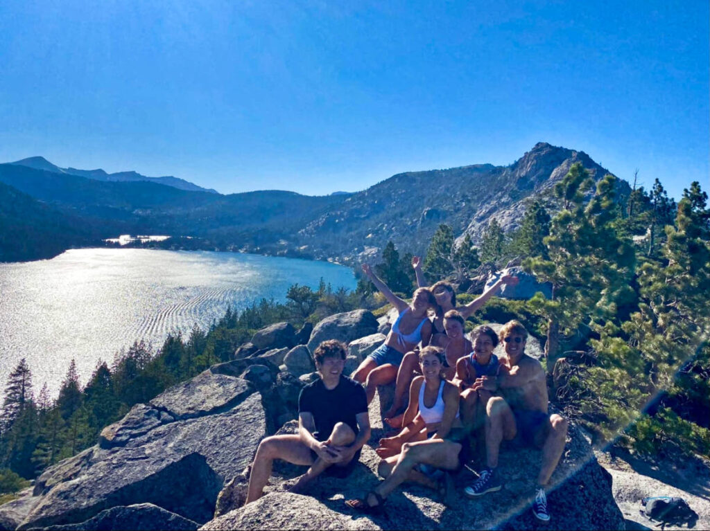 The author Laura McFarland and her friends, smiling for a photo at the lookout point over Lower Echo Lake