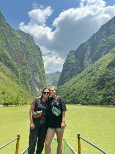 The author Laura McFarland and her partner posing for a photo with a scenic view in the background