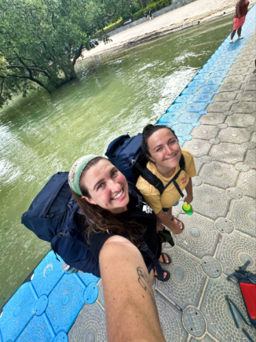 The author Laura McFarland and her partner smiling for a photo while carrying their backpacks