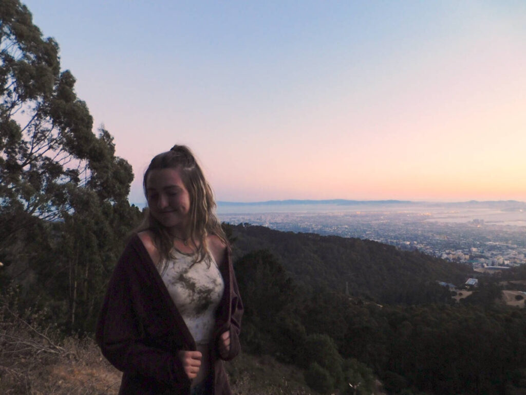 The author Laura McFarland, smiling for a photo at Grizzly Peak at sunset