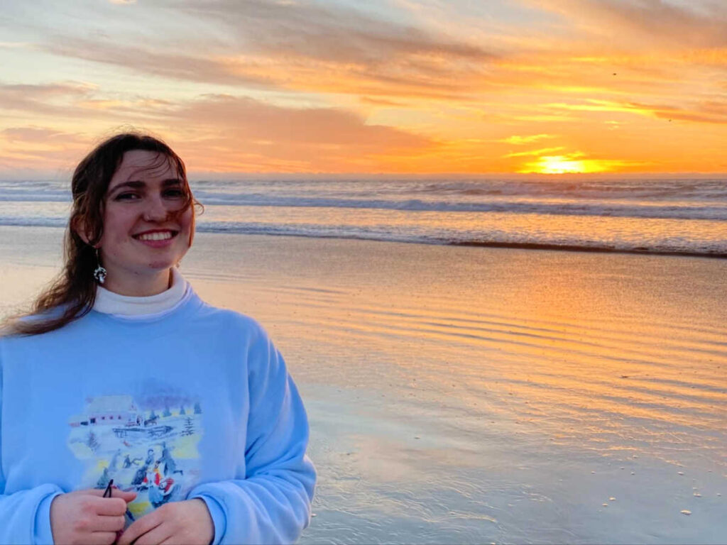 The author Laura at the Ocean Beach with a scenic view of the sunset in the background