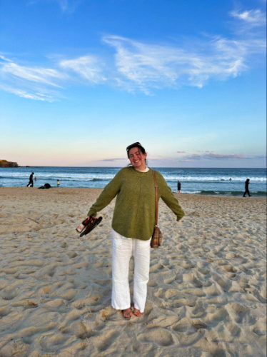 The author Laura McFarland wearing a light sweater at the beach in Australia