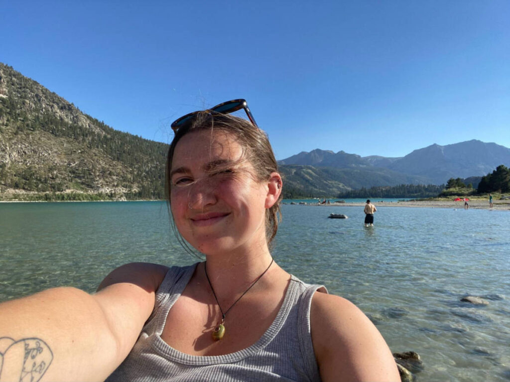 The author Laura McFarland, smiling for a photo in June Lake on a sunny day