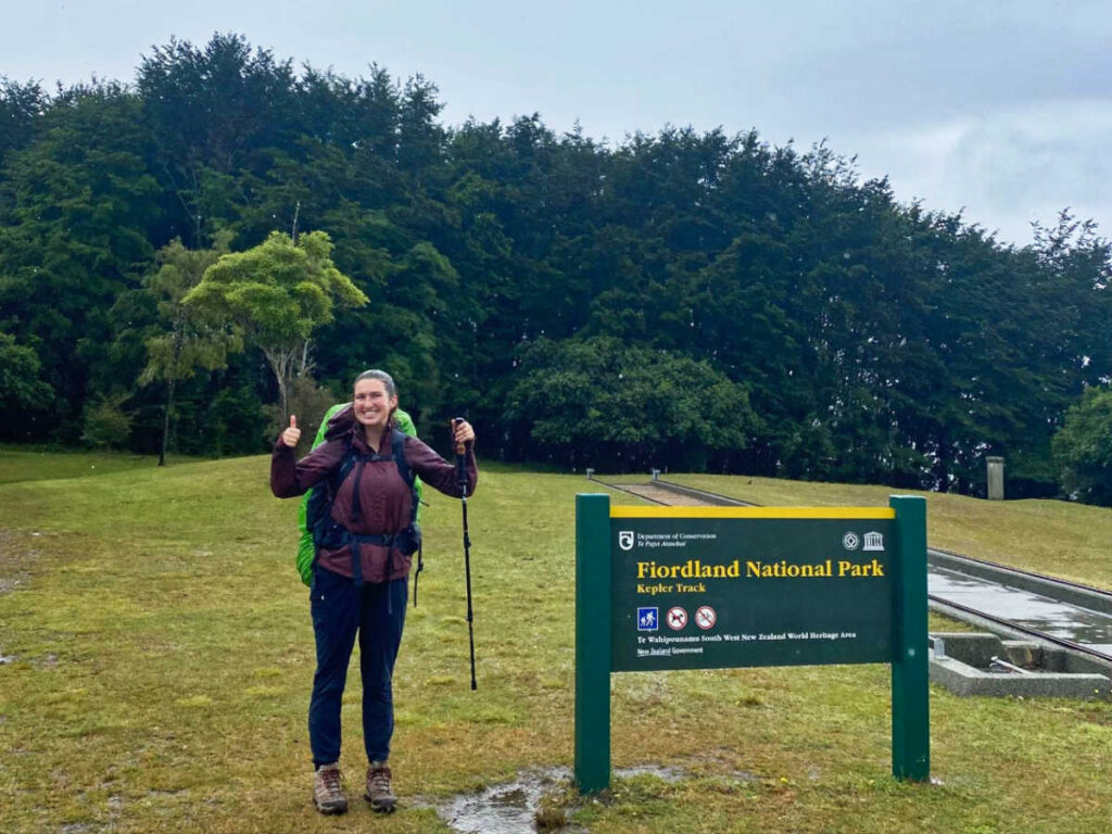 The author Laura McFarland posing for a photo near the signage of Kepler Track