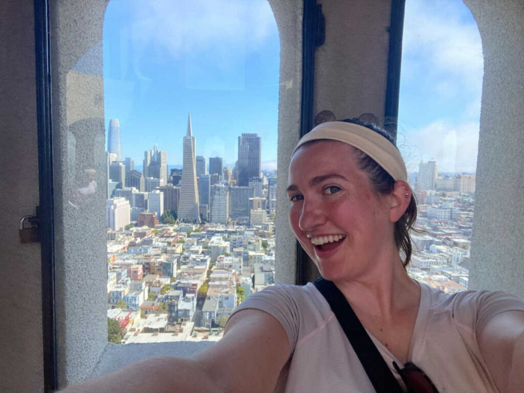The author Laura McFarland smiling for a photo at the top of Coit Tower