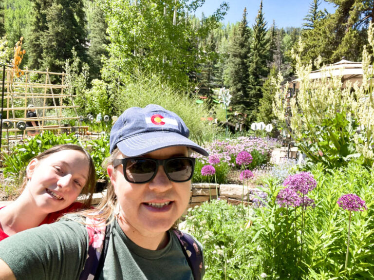 Thea author Laura Falin and her child smiling for a photo at the beautiful landscape of Children’s Garden