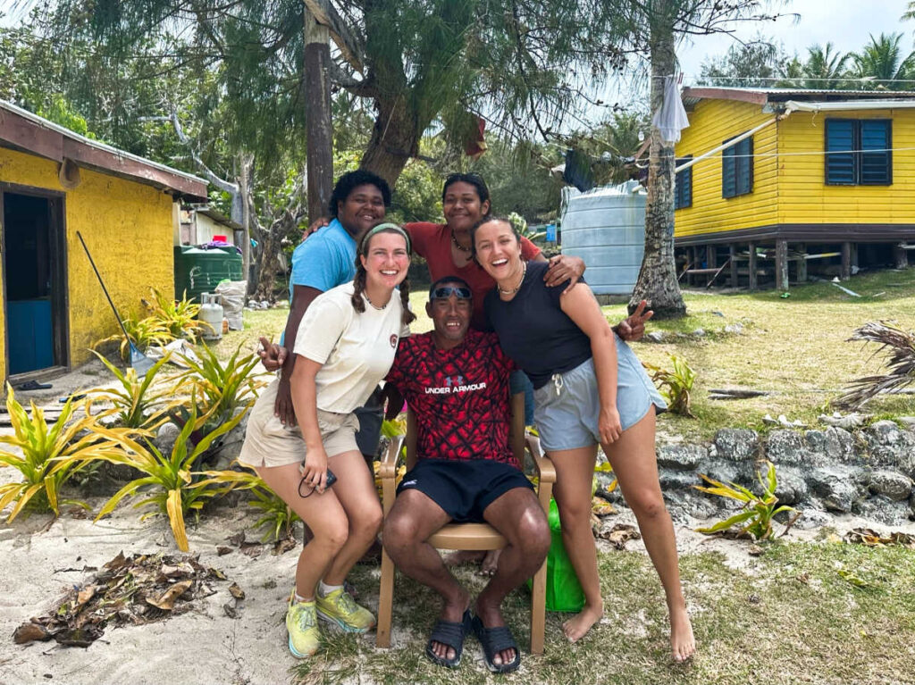 The author Laura McFarland and her partner smiling for a photo with their homestay hosts