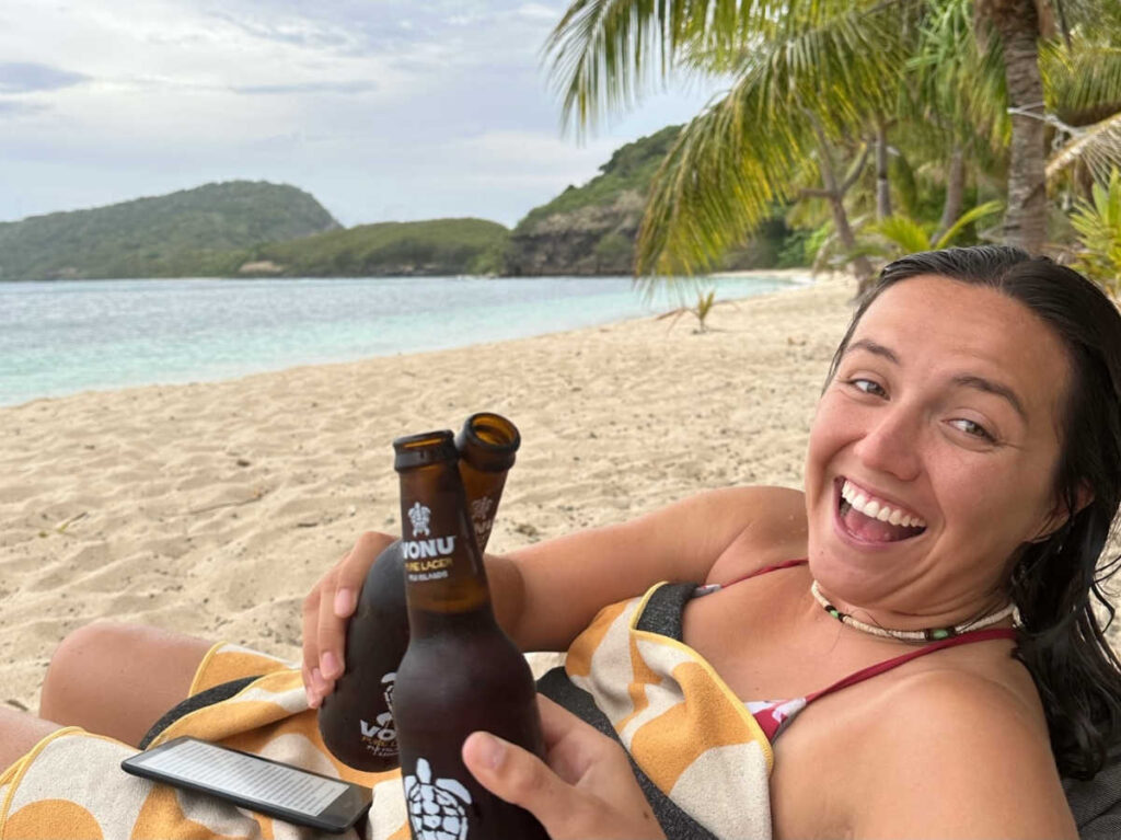 The author's partner clinking bottles of beer on the island