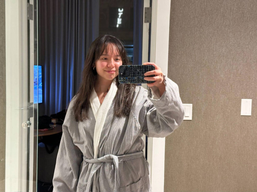 The author, Lea Rose Allbaugh smiling for a mirror selfie on the bathroom