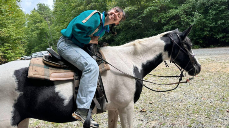 The author, Lea Rose Allbaugh riding a horse outside of Asheville