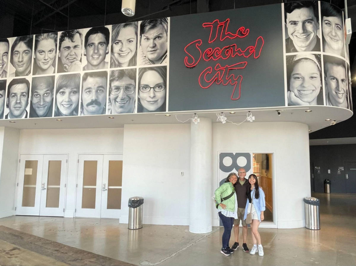 The author Lea Rose Allbaugh and her family in front of the posters in the Second City
