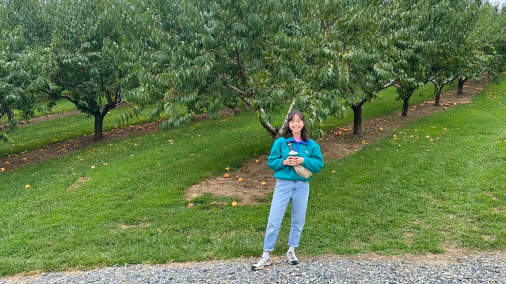 The author Lea Rose, posing for a photo at the Jeter Mountain Farm surrounded by greenery