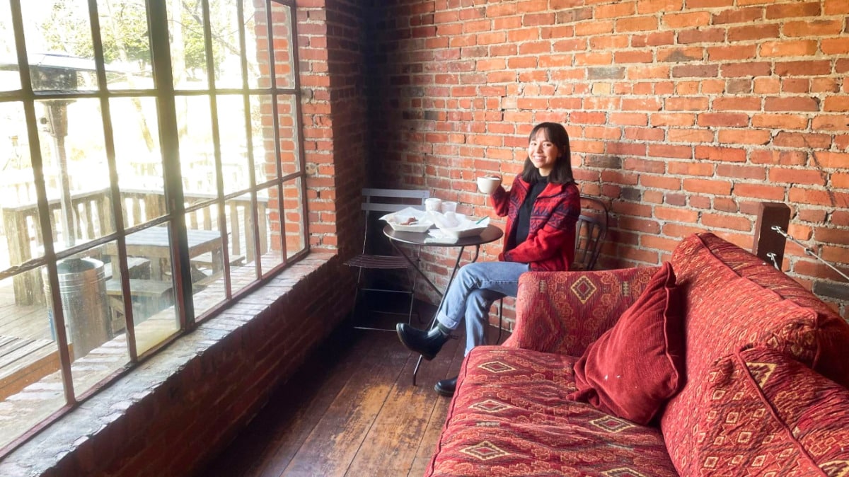 Travel Lemming Writer, Lea Rose having coffee in the corner table of Panacea CoffeeHouse