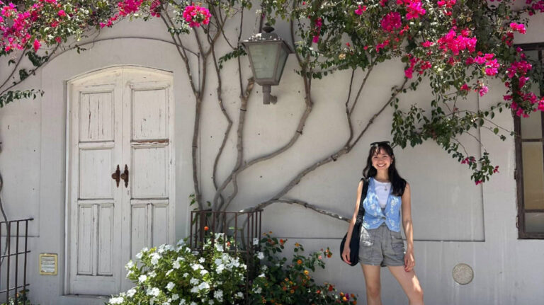 The author Lea Rose Allbaugh, standing near the blooming flowers in Todos Santos, Mexico