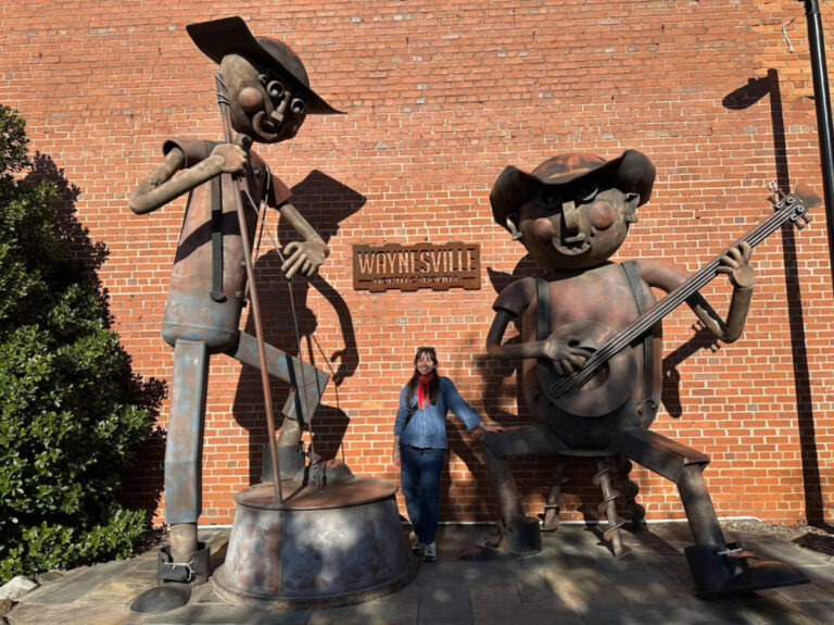 The author Lea Rose Allbaugh, standing in between the huge statues in Waynesville