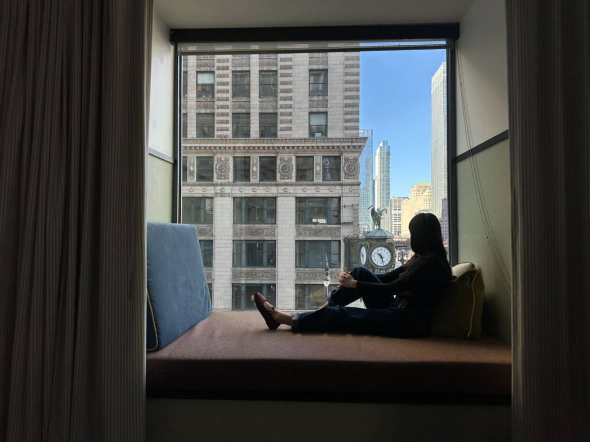 The author Lea Rose Allbaugh, enjoying the view while sitting by the window nook at the L7 Chicago by Lotte