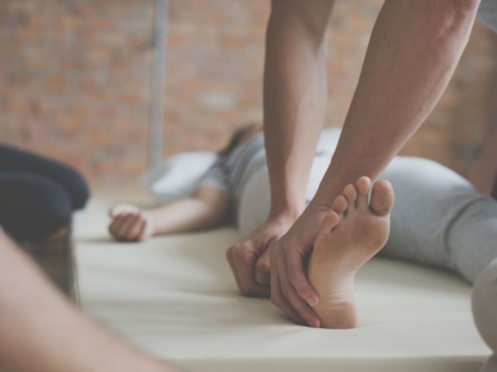 A person massaging a clients feet