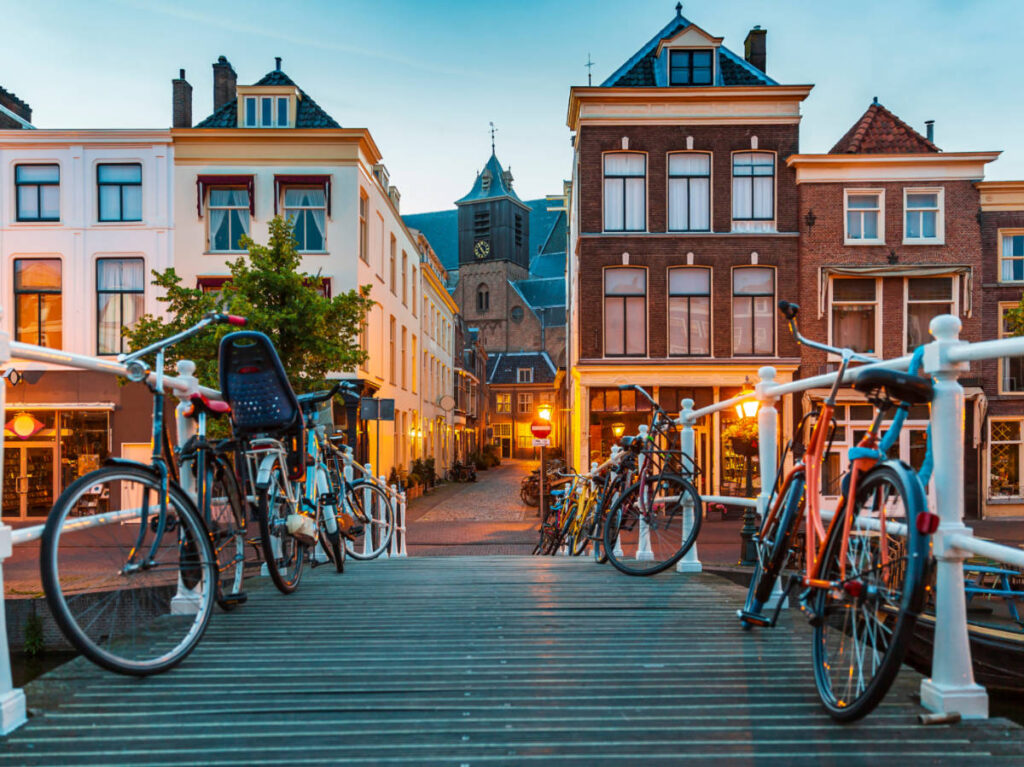 The illuminated buildings and bicycles on the bridge near the Leiden’s Canals