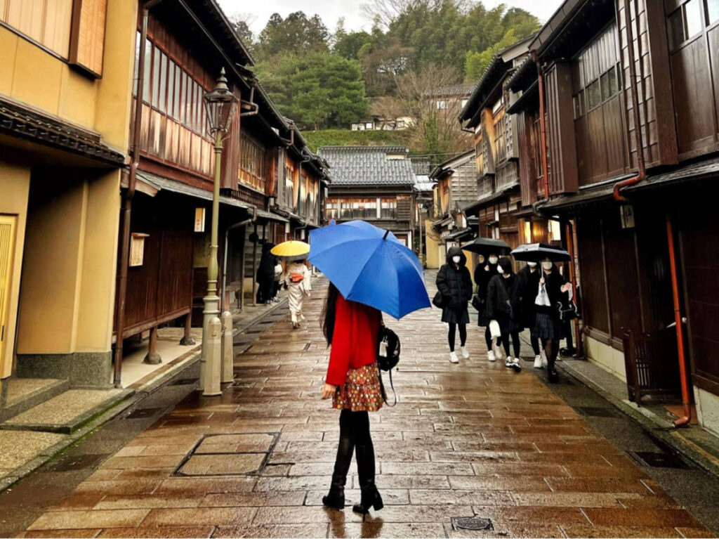 The author Lia Tee, walking in Higashi Chaya with an umbrella on a rainy day