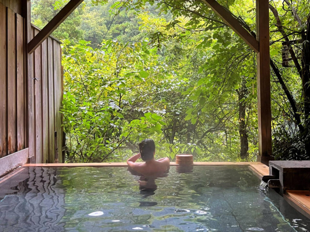 The author Lia Tee, relaxing on the private outdoor onsen in Yamanaka Onsen town