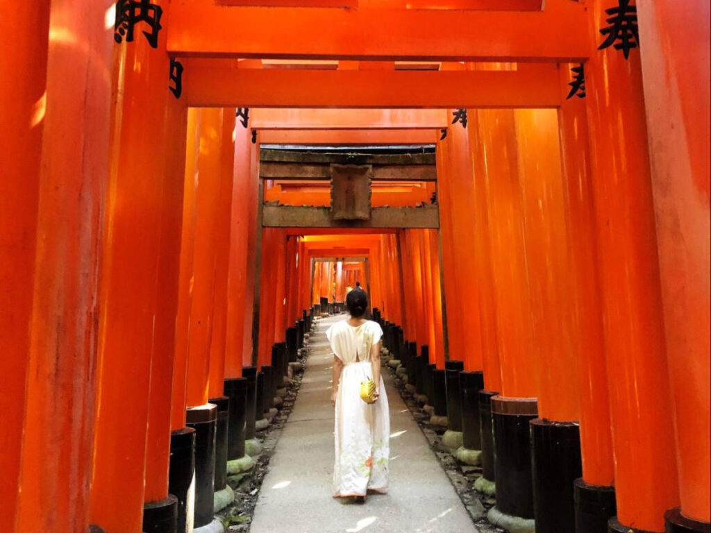 The author Lia Tee, walking along the bright vermillion torii gates in Fushimi Inari Taisha
