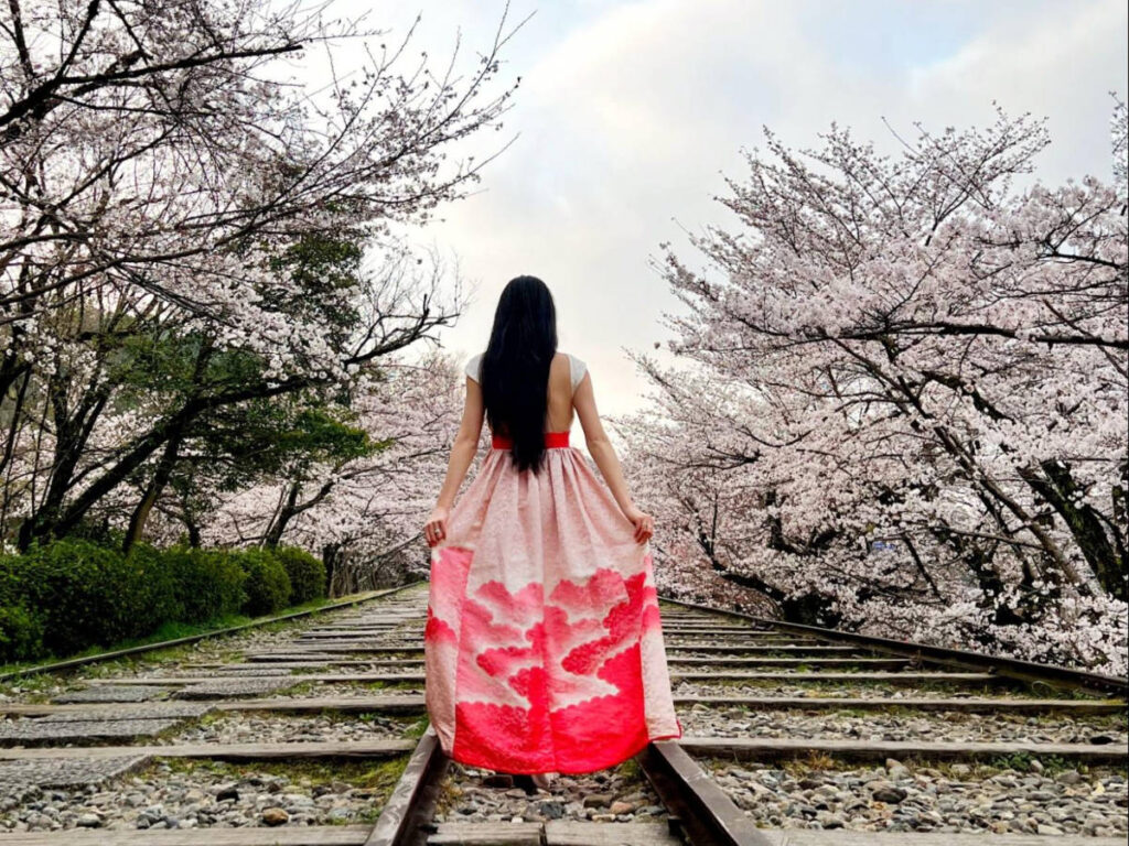 The author Lia Tee, posing for a photo in Keage Incline with sakura trees around