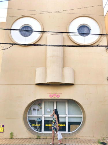 The author Lia Tee, posing for a photo in front of the infamous The Face House