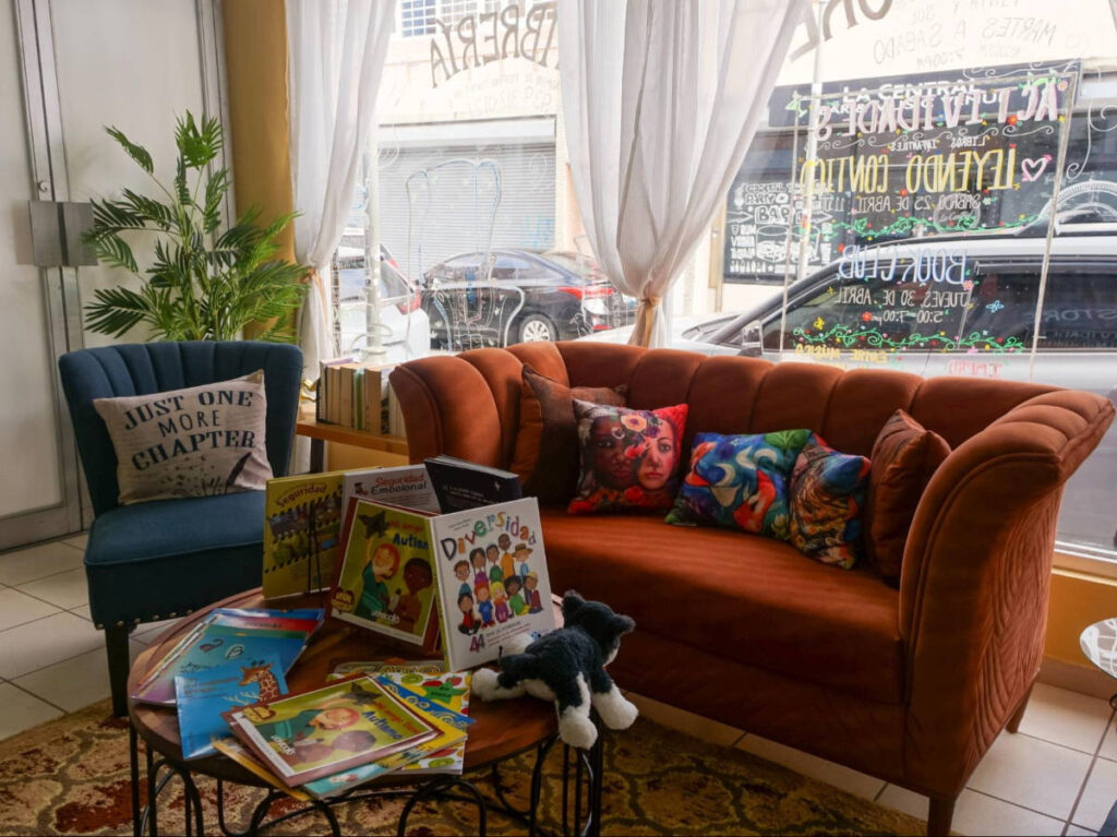 A colorful seating area with books on the center table in Librería Tinta y Sol