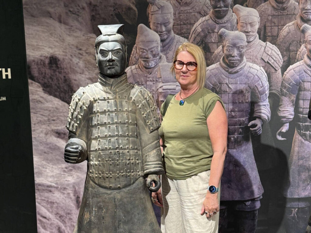 The author Lisa Ikin standing next to the Terracotta Warrior at WA Museum
