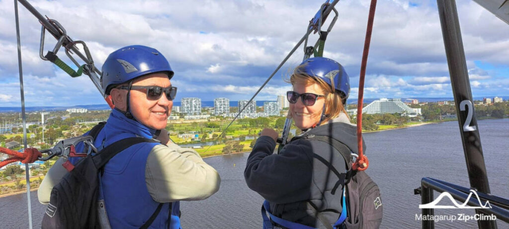 The author Lisa Ikin and her partner, smiling for a photo at the Matagarup Bridge Zip+Climb