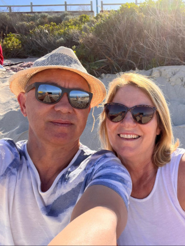 The author Lisa Ikin and her partner, taking a photo together in Trigg Beach at sunset