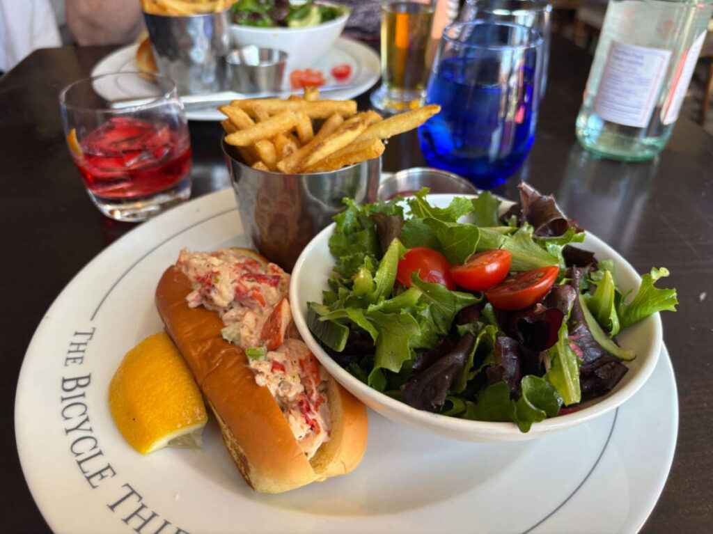 A plate of lobster rolls with salad and fries on the side at The Bicycle Thief